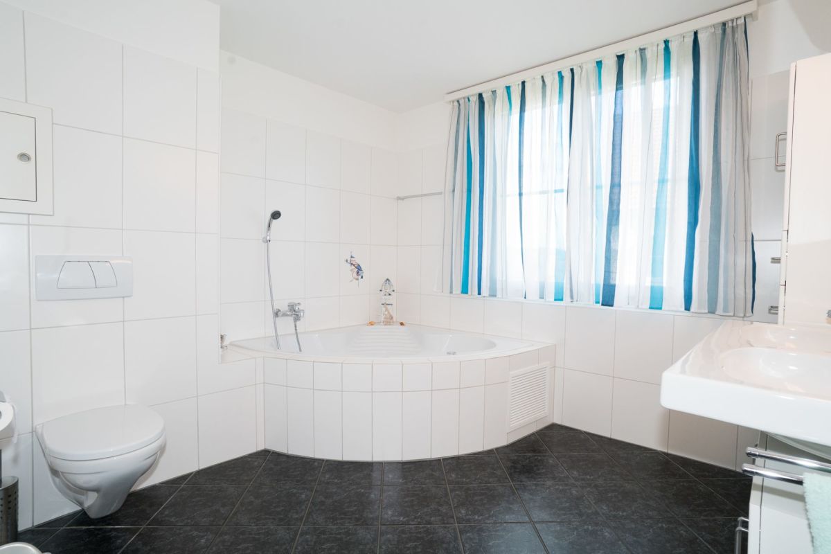 Helles Badezimmer mit Badewanne und WC