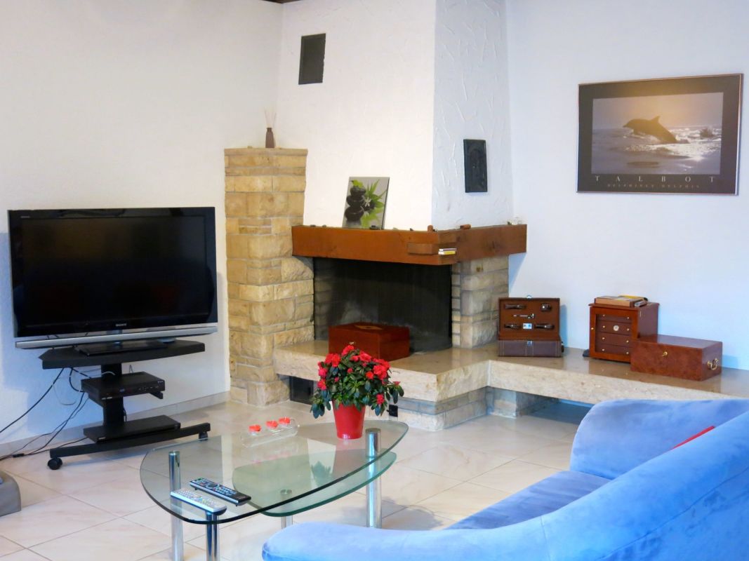 Wohnzimmer mit Kamin und TV-Ecke
