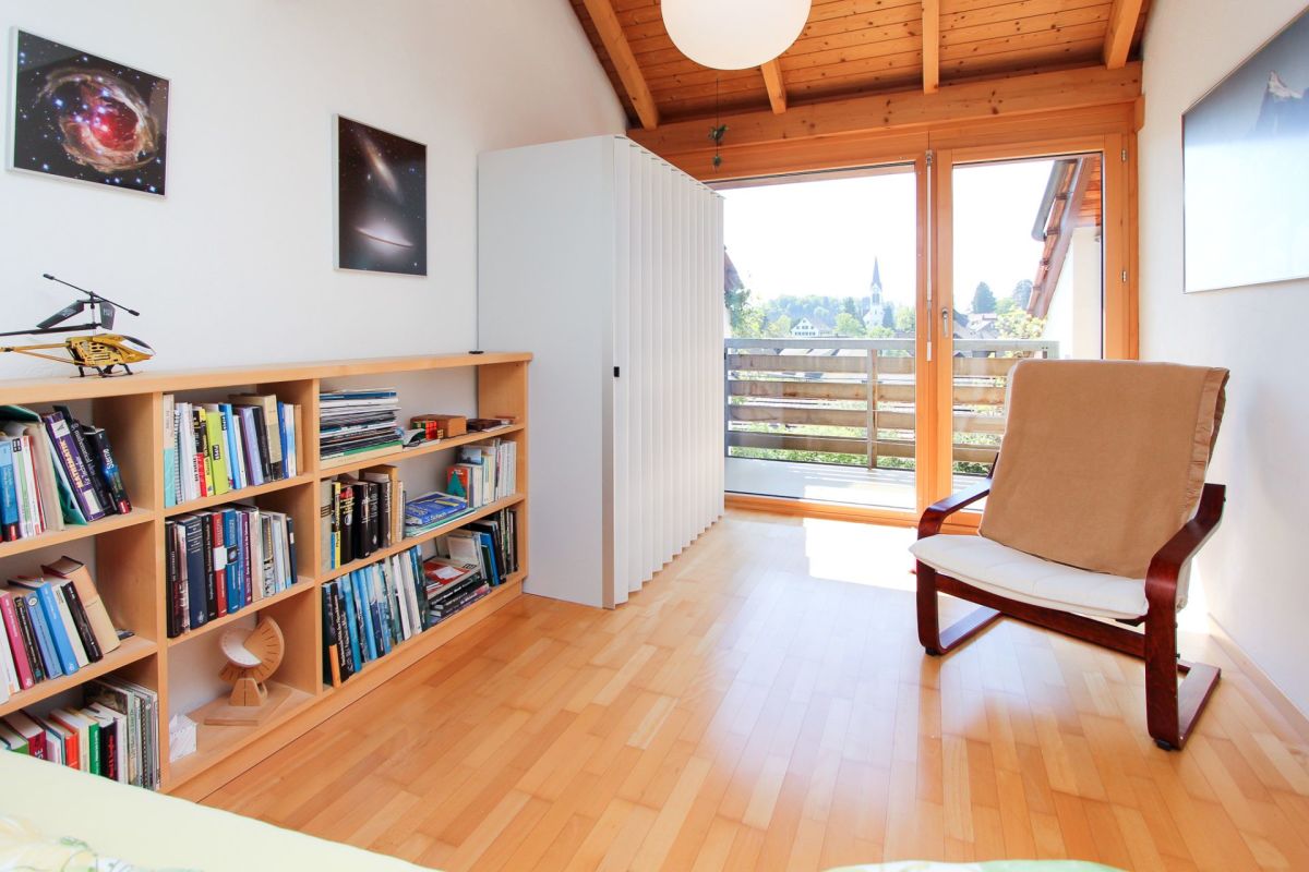 Helles Zimmer mit Balkon und Bücherregal