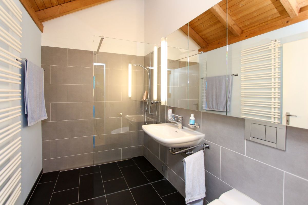 Modernes Badezimmer mit Holzbalkendecke