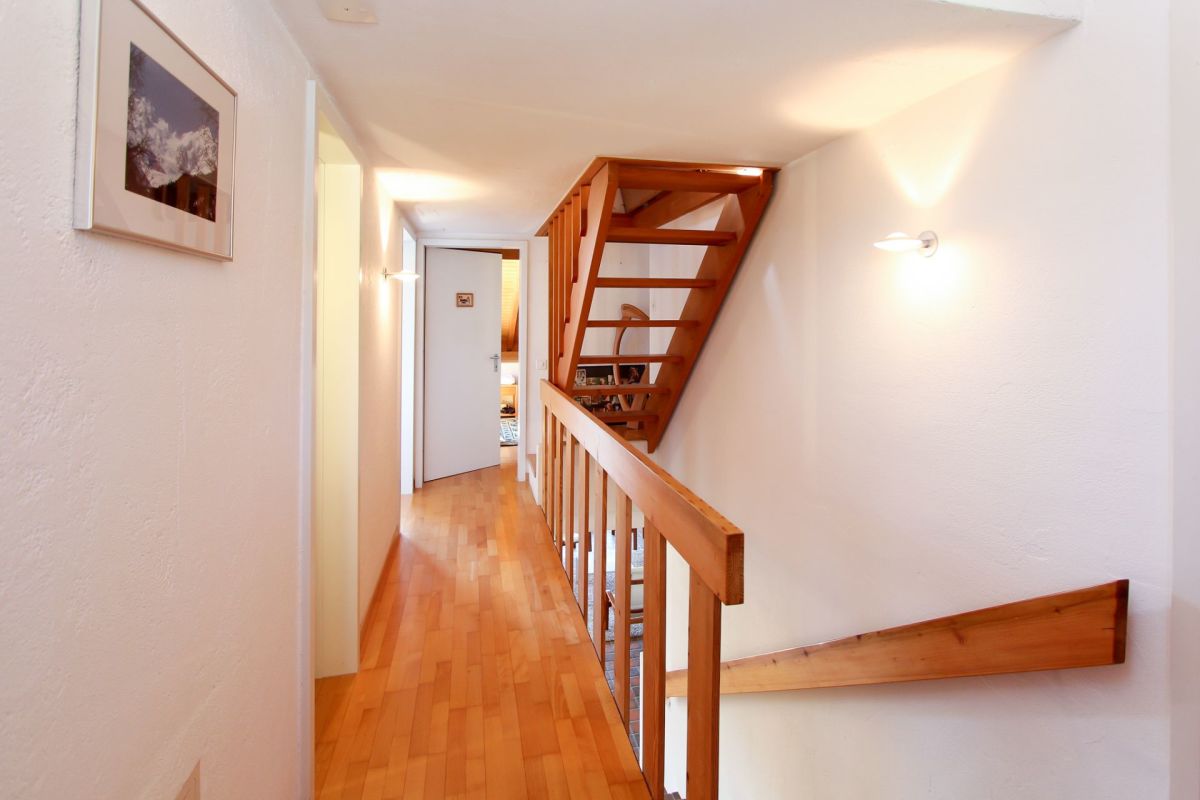 Heller Flur mit Holztreppe