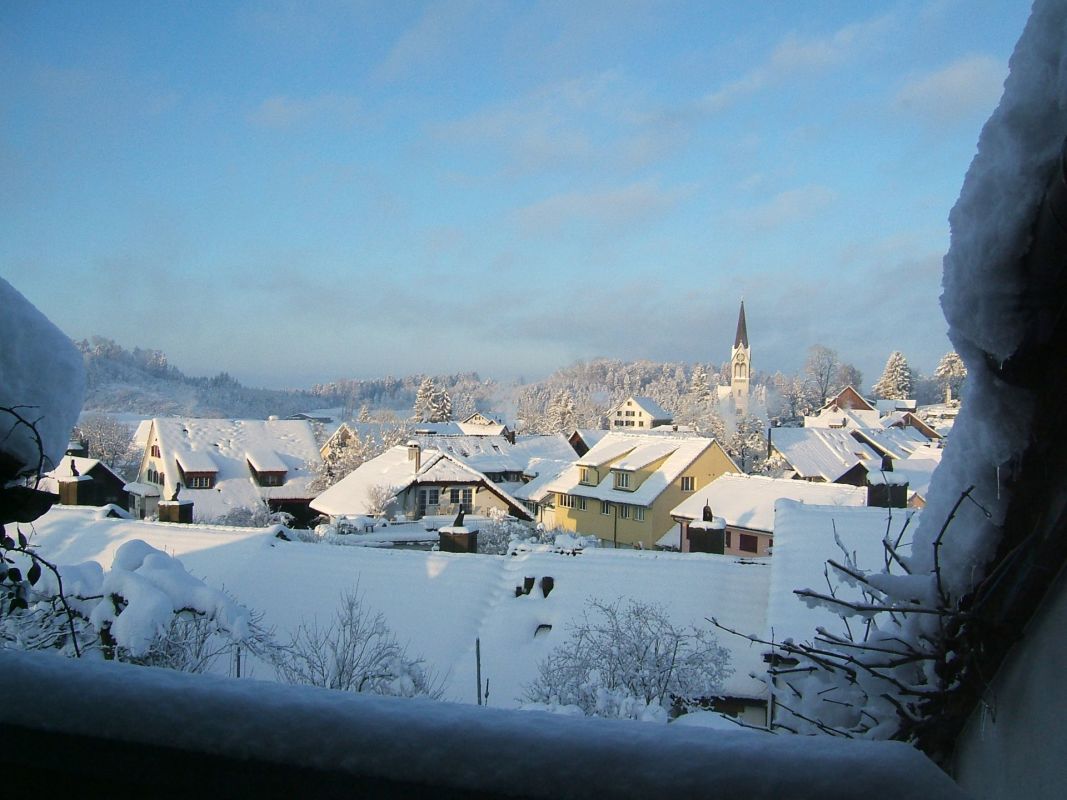 Verschneites Dorf mit Häusern und Kirchturm