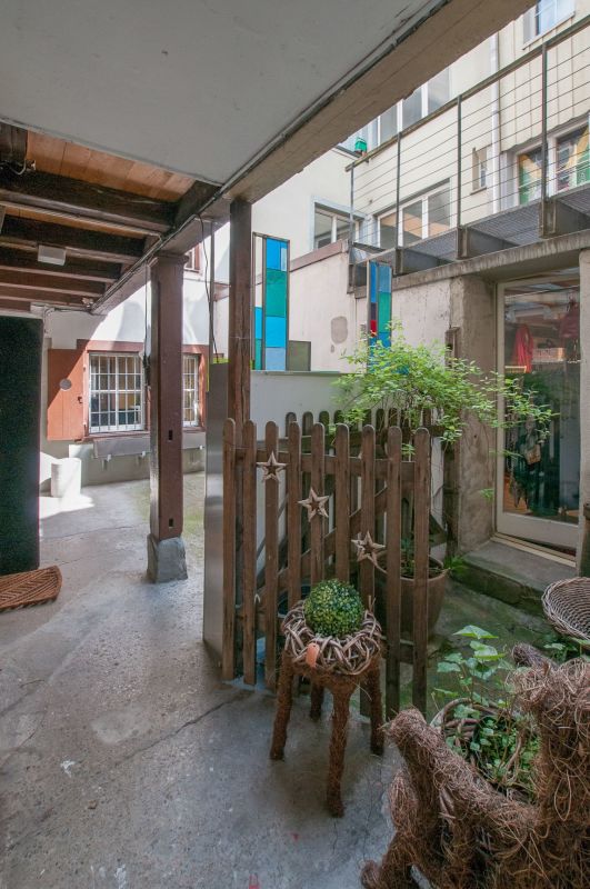 Innenhof mit überdachtem Gang und kleiner Gartenfläche