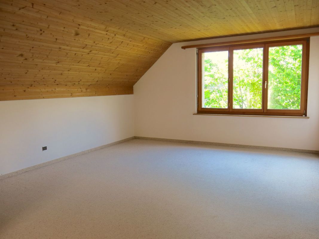 Leerer Dachraum mit Holzdecke und Fenster
