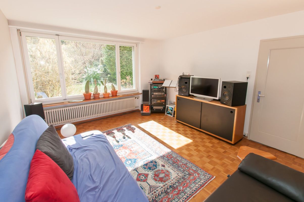 Helles Wohnzimmer mit Fensterfront und Stereoanlage