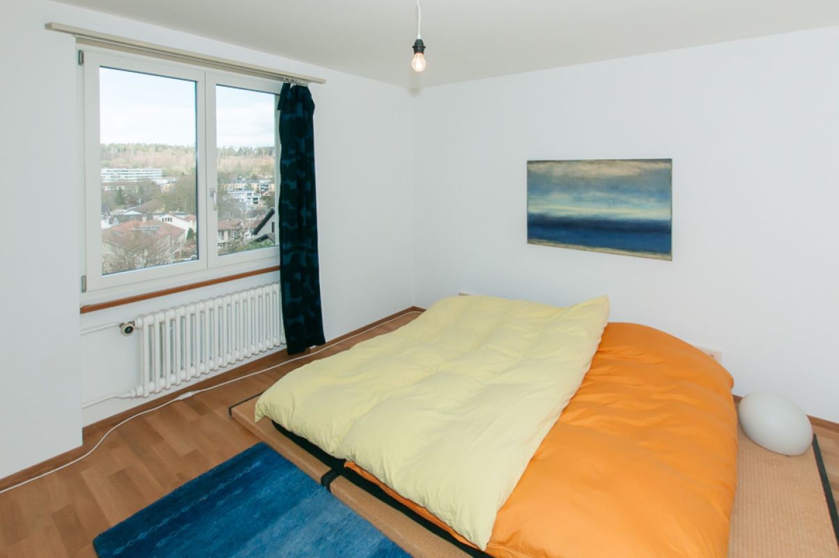 Helles Schlafzimmer mit Doppelbett und Fensterblick
