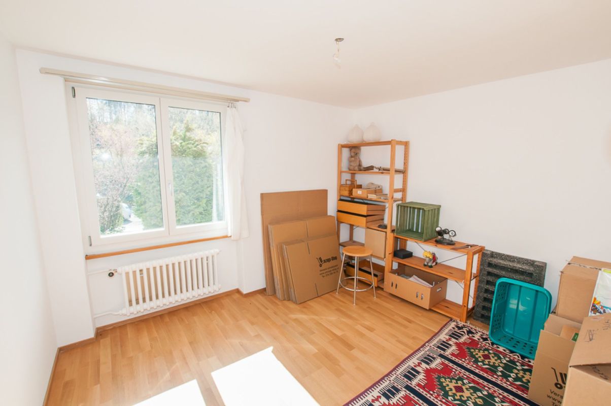Helles, teilmöbliertes Zimmer mit Fenster und Heizkörper