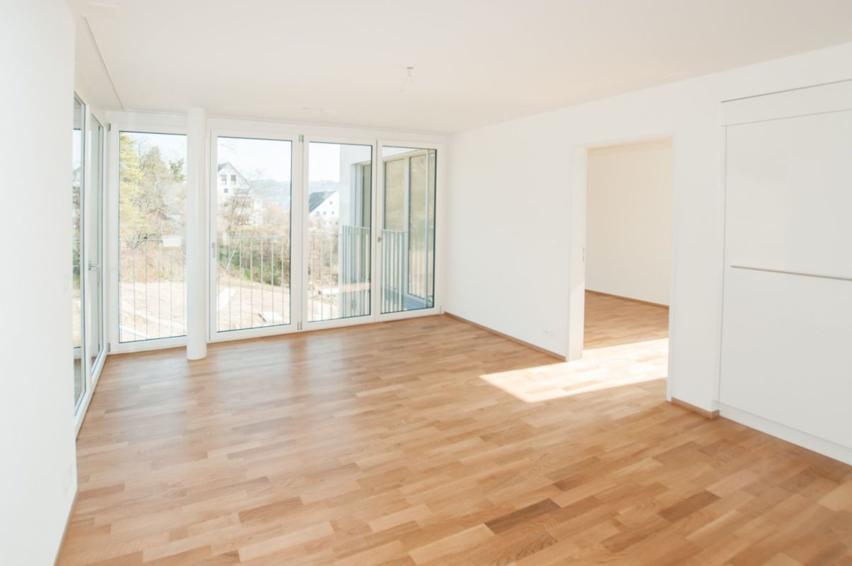 Heller leerer Wohnraum mit Balkonfenstern