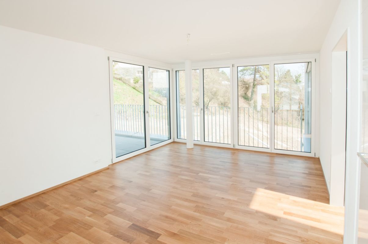 Heller leerer Wohnraum mit großen Fensterfronten