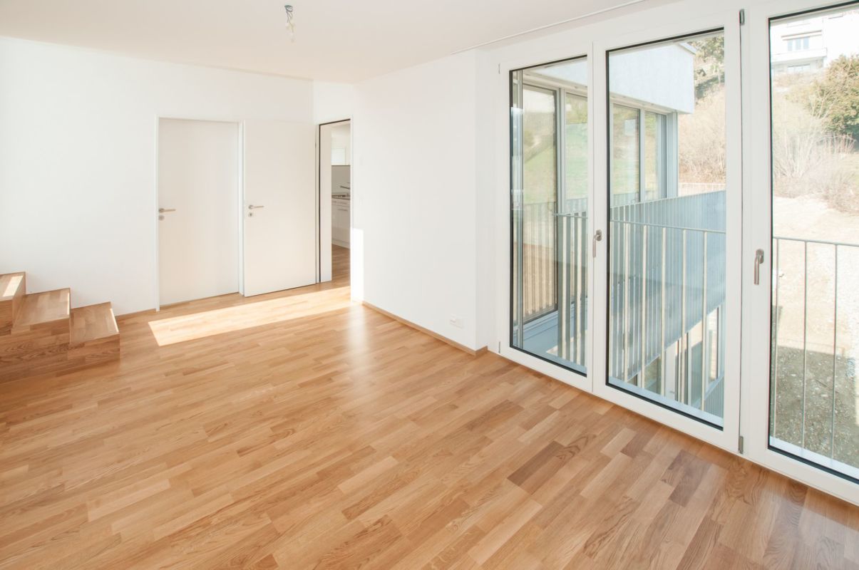 Heller Wohnraum mit Parkett und großen Fenstern