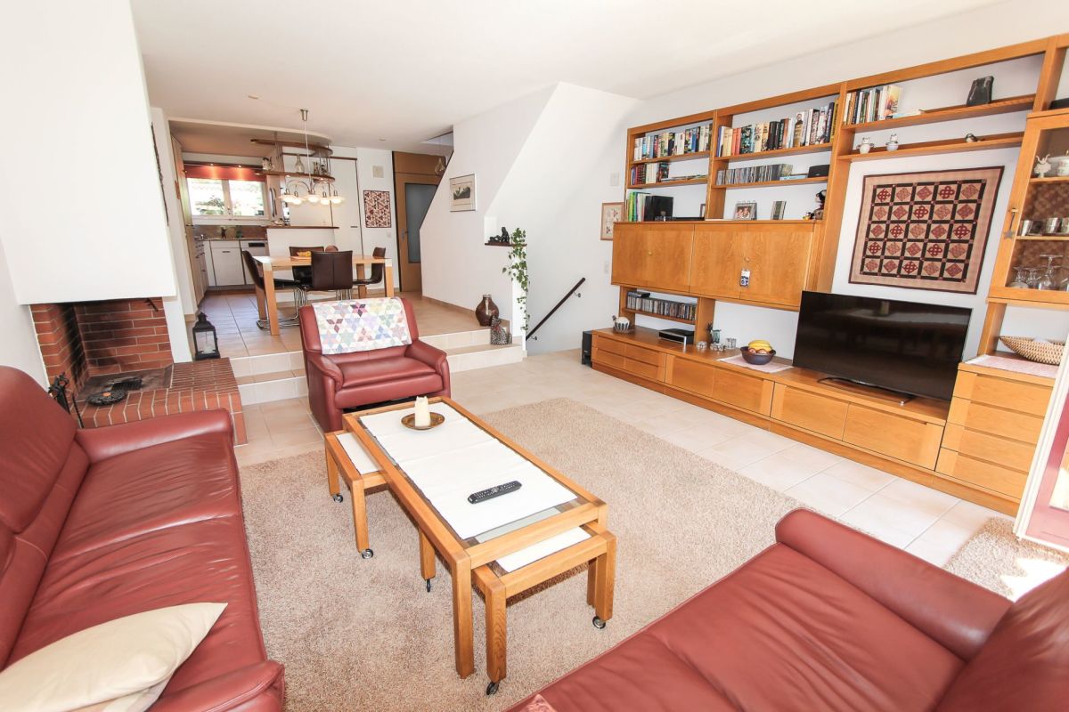 Wohnzimmer mit Kamin und offener Blickachse zum Essbereich