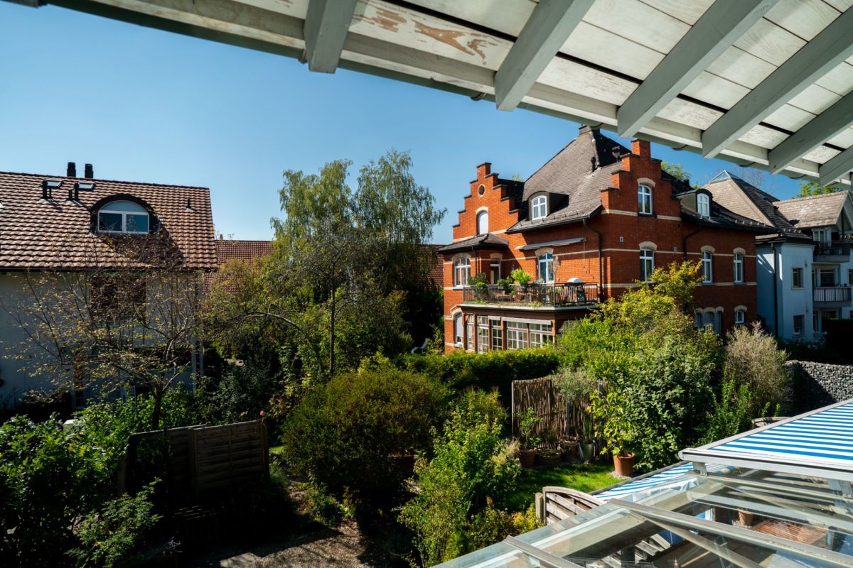 Blick über einen begrünten Innenhof mit historischen Wohnhäusern