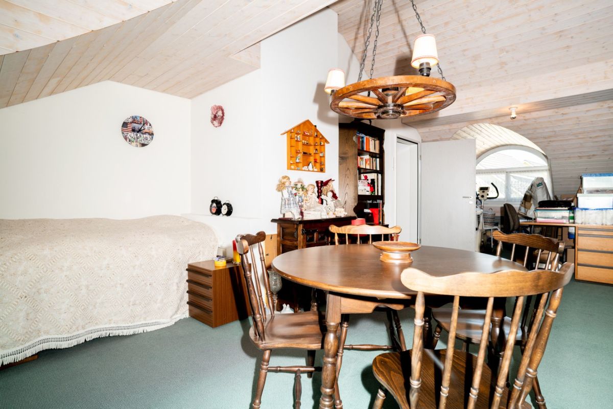 Dachgeschosszimmer mit Esstisch und Bett