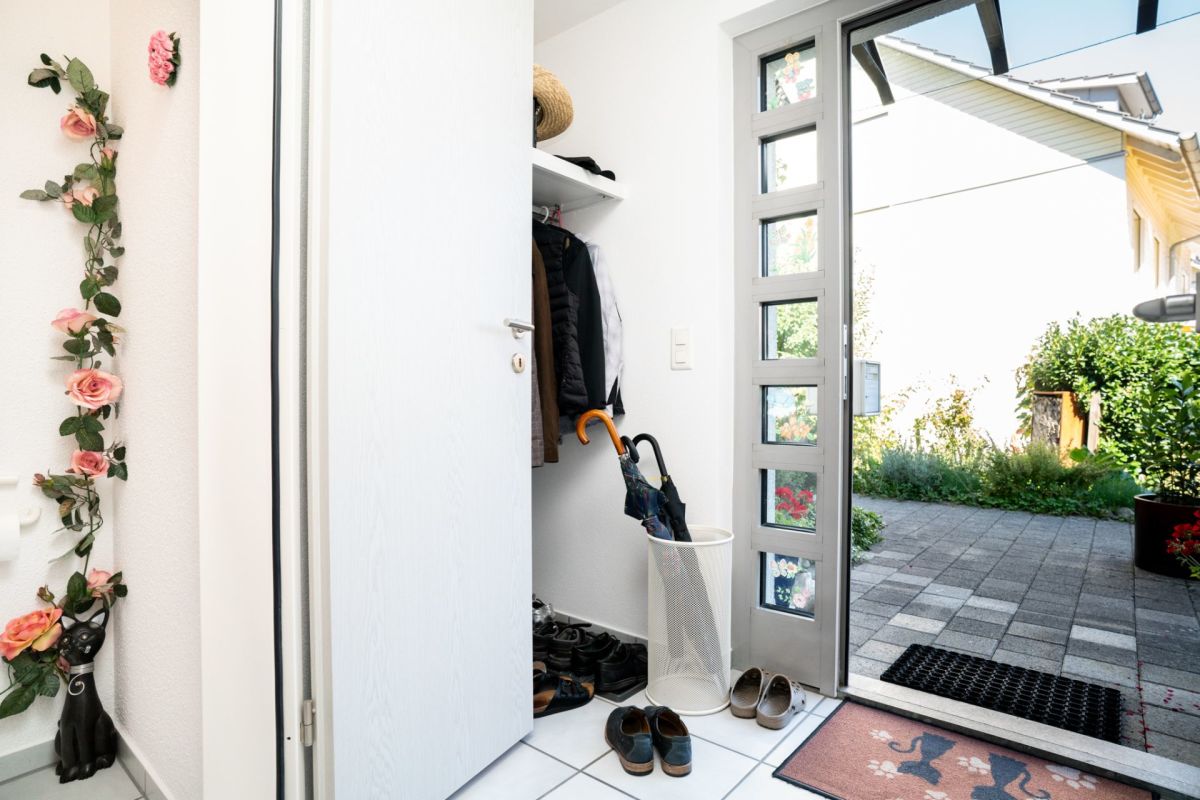 Eingangsbereich mit offener Haustür zum Garten