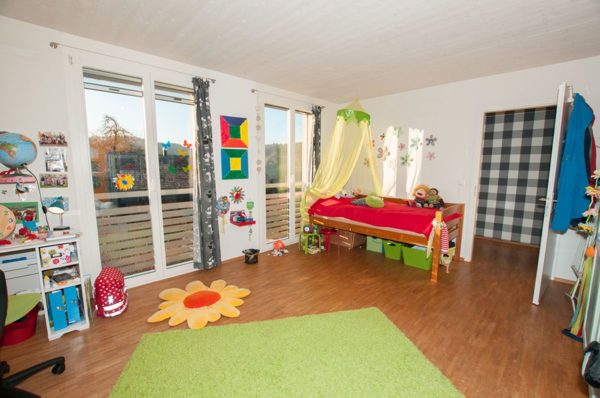 Buntes Kinderzimmer mit großen Fenstern