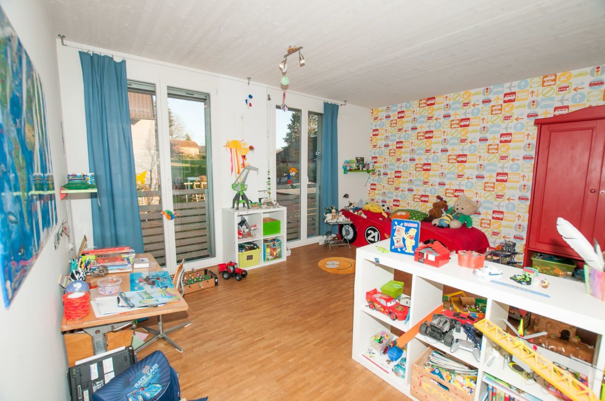 Kinderzimmer mit Spielmöbeln und Schreibtisch