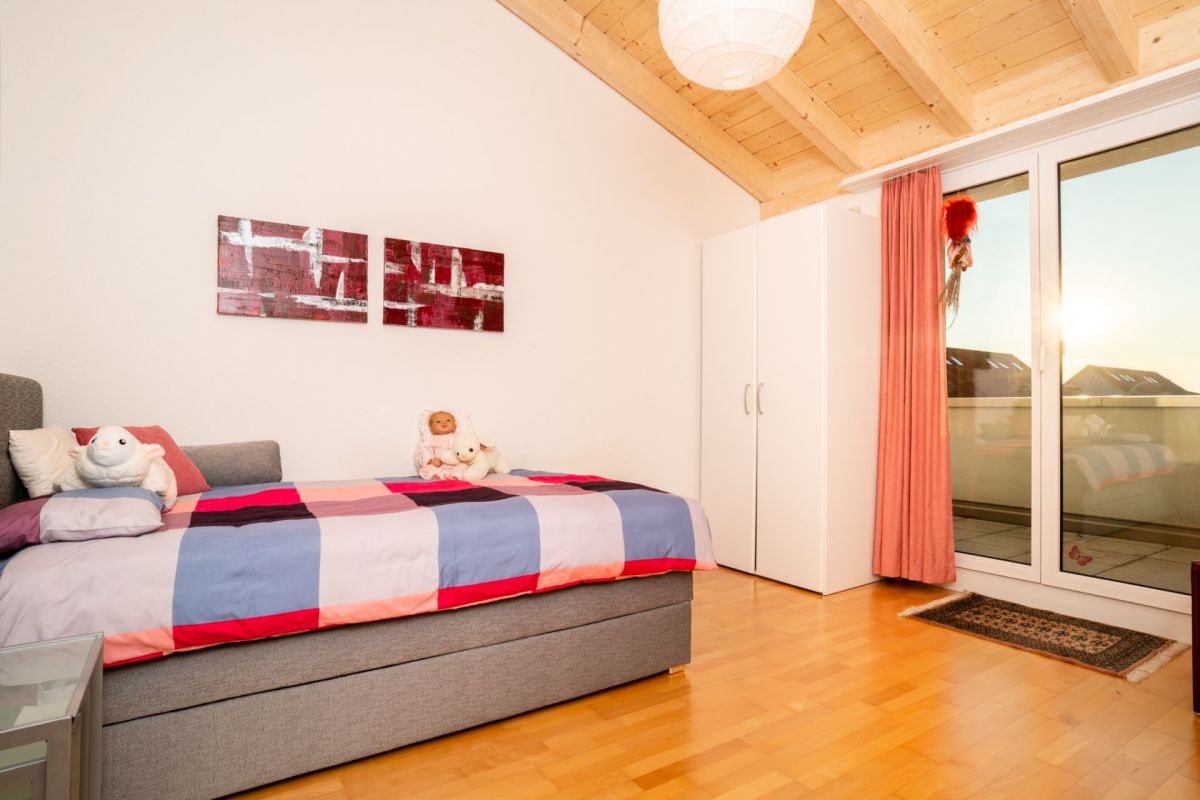 Helles Schlafzimmer mit Dachschräge und Balkon