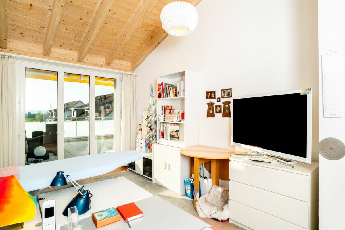 Helles Dachgeschosszimmer mit Balkon und Arbeitsbereich