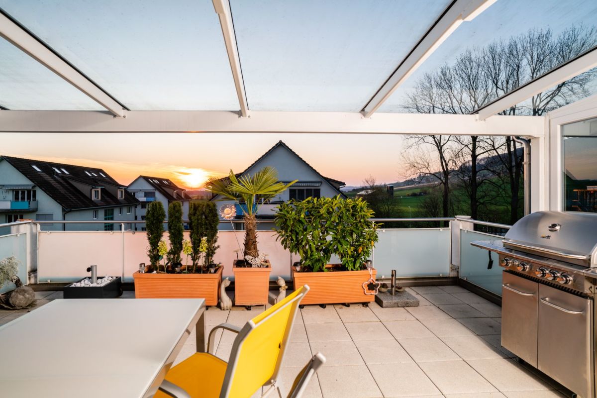 Dachterrasse mit Grill und Sonnenuntergang