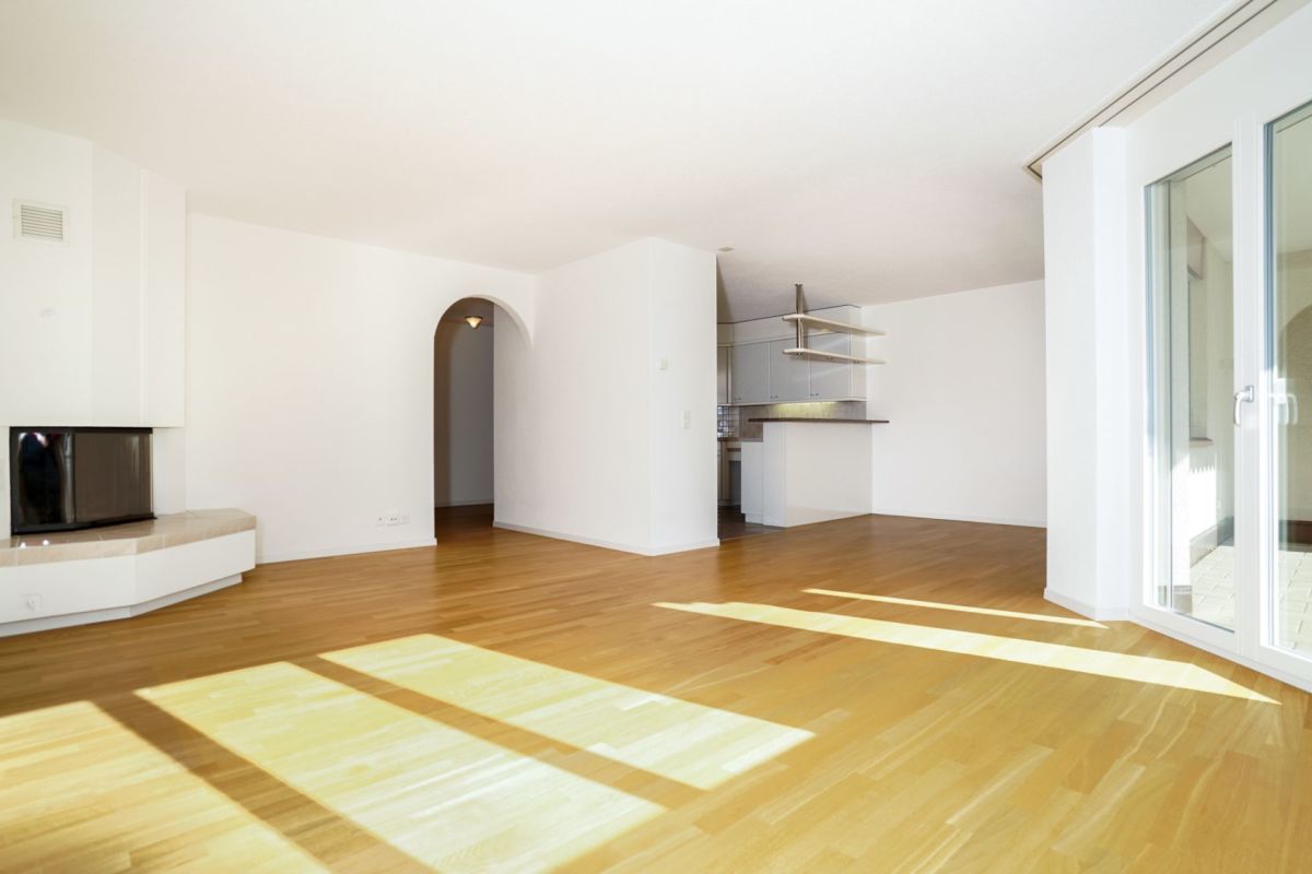 Helles, offenes Wohnzimmer mit Zugang zur Küche und Balkon