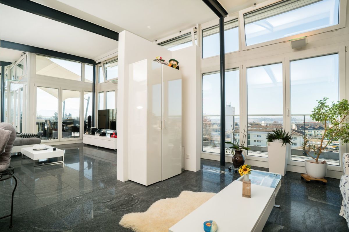 Modernes Wohnzimmer mit bodentiefen Fenstern und Stadtblick