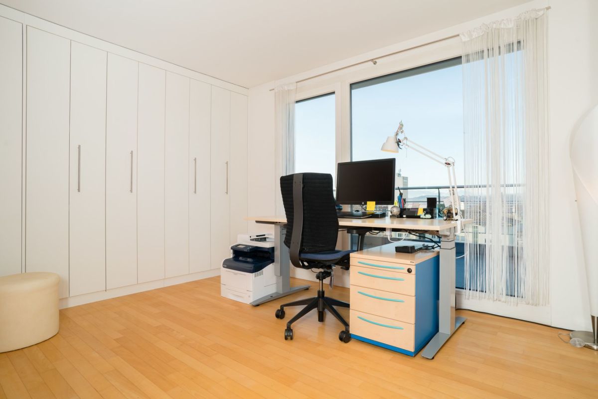 Arbeitszimmer mit Einbauschrank und Schreibtisch am Fenster