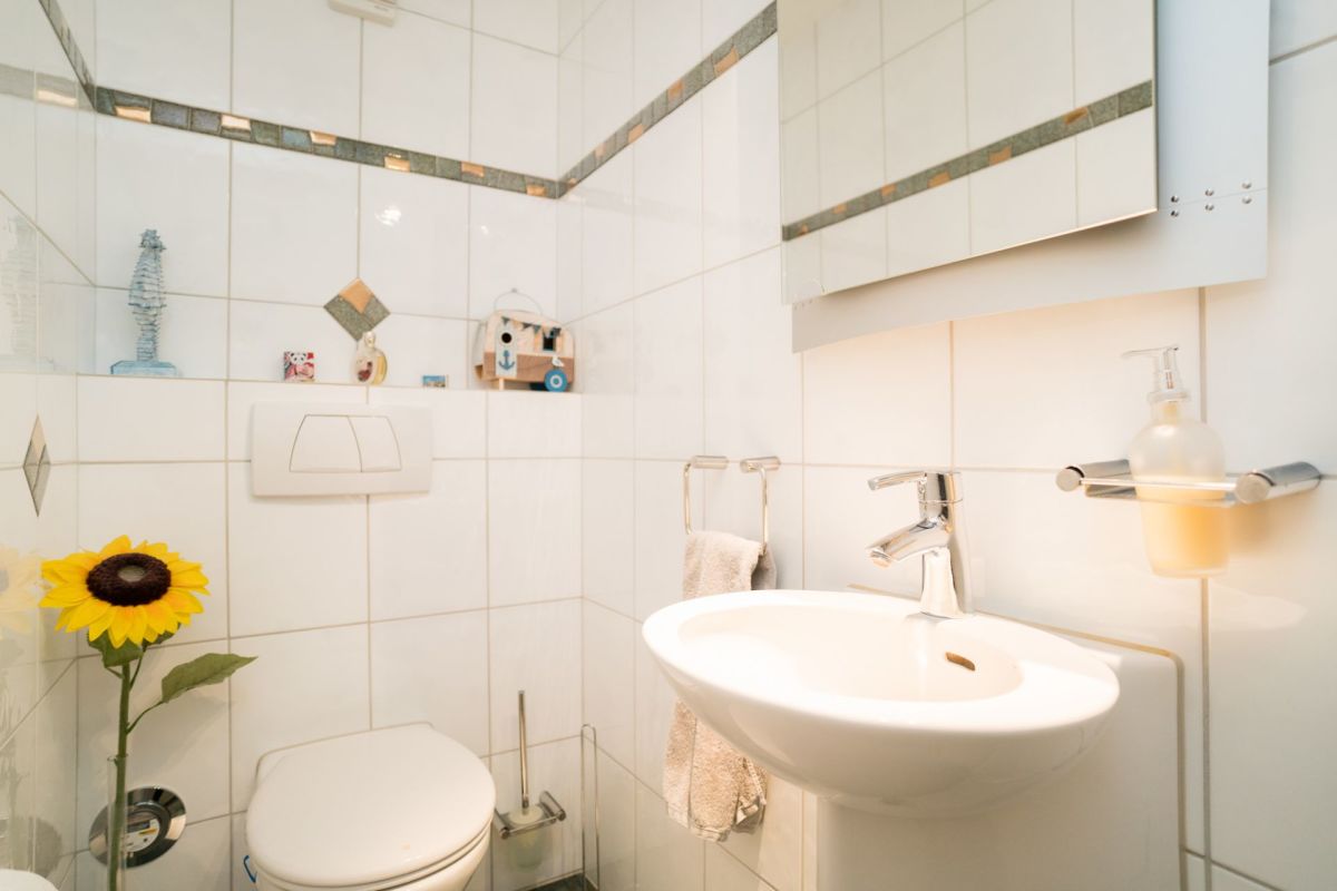 Gäste-WC mit Waschbecken und dekorierten Fliesen