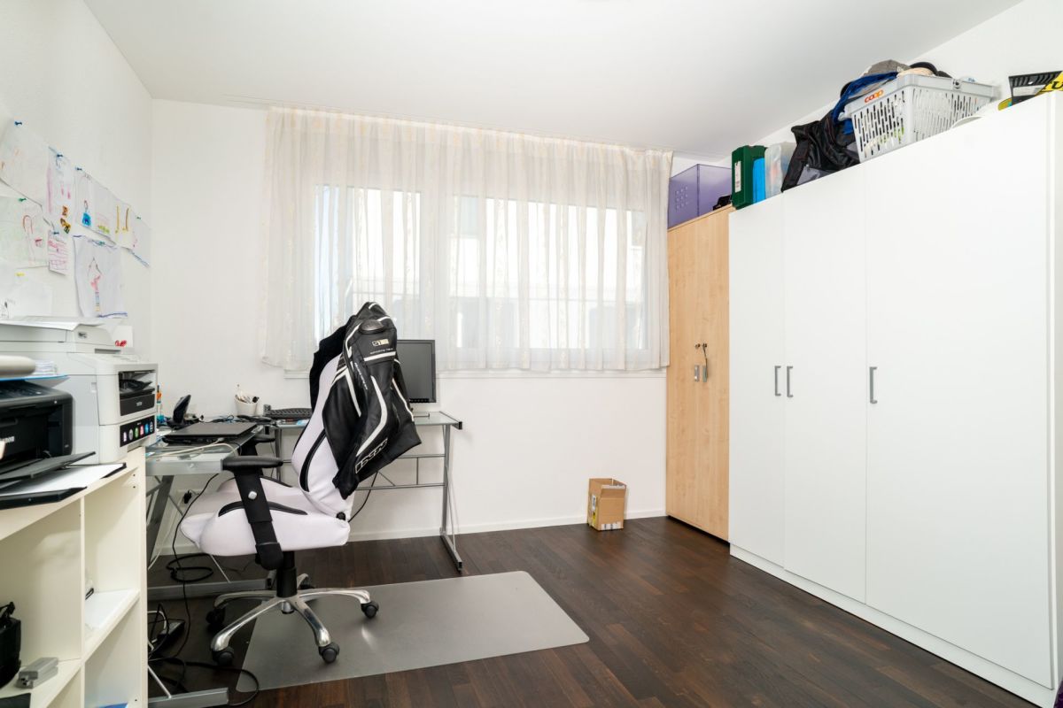 Arbeitszimmer mit Schreibtisch und Schrankwand