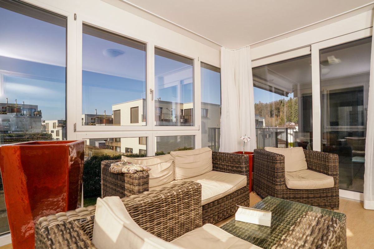 Lichtdurchfluteter Balkon-Wohnbereich mit Rattanmöbeln