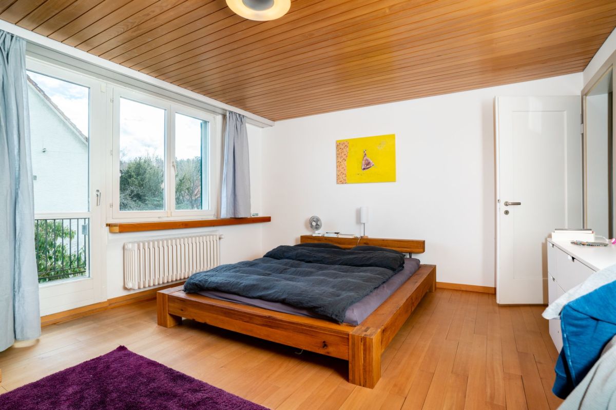 Helles Schlafzimmer mit Holzboden und Holzdecke