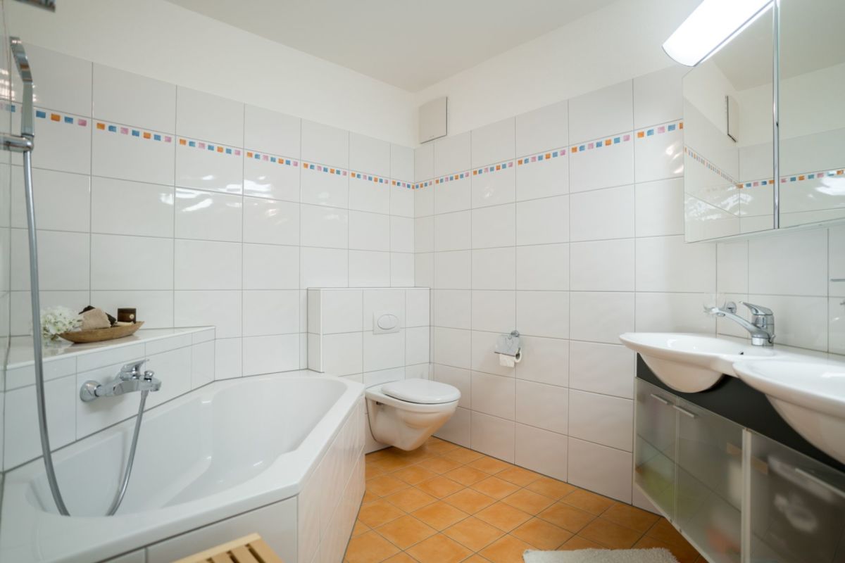 Helles Badezimmer mit Badewanne, WC und Doppelwaschtisch