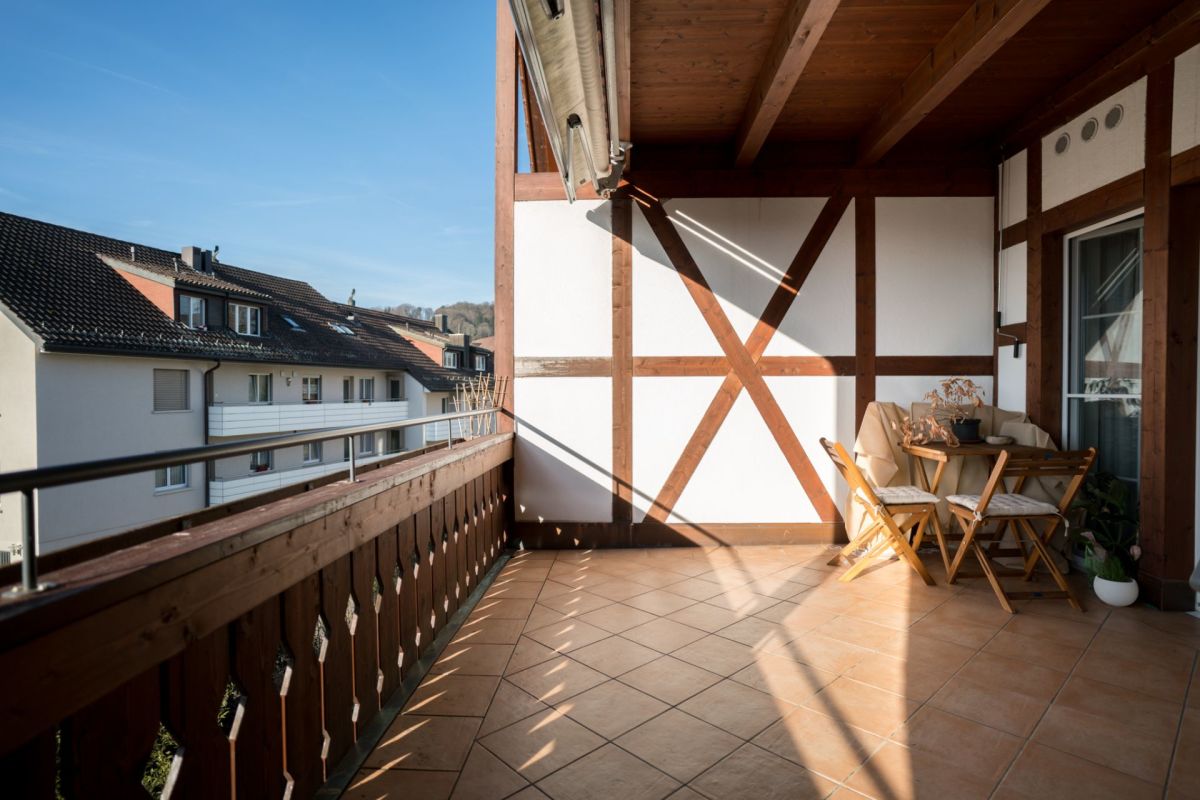 Balkon mit Holzgeländer und Sitzgruppe