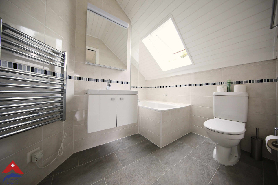 Helles Badezimmer mit Dachfenster und Badewanne