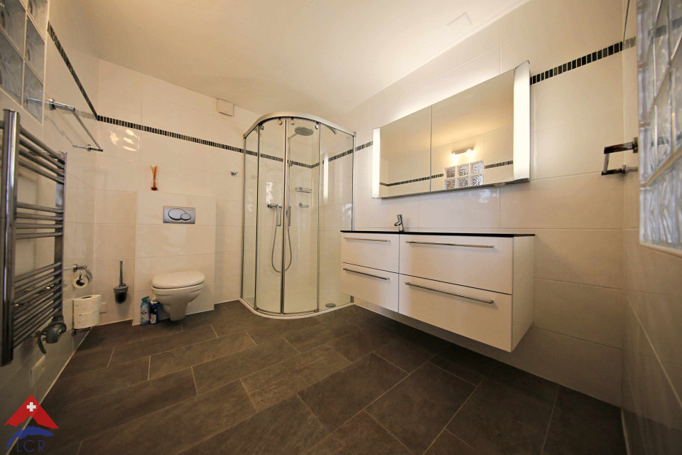 Modernes Badezimmer mit begehbarer Dusche und Spiegelschrank