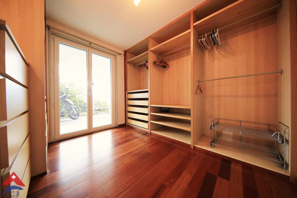 Ankleidezimmer mit Holzschrank und Terrassentür