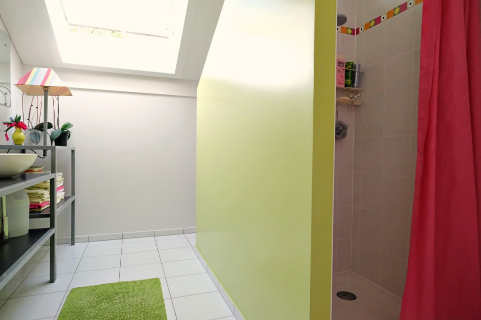 Badezimmer mit Dachfenster und farbenfroher Dusche