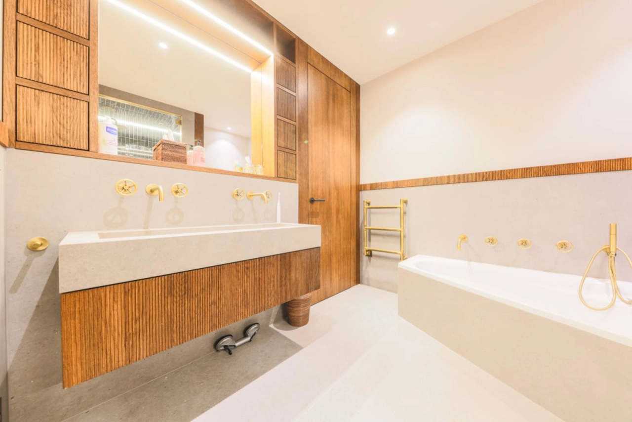 Modernes Bad mit Holzoptik und goldenen Armaturen