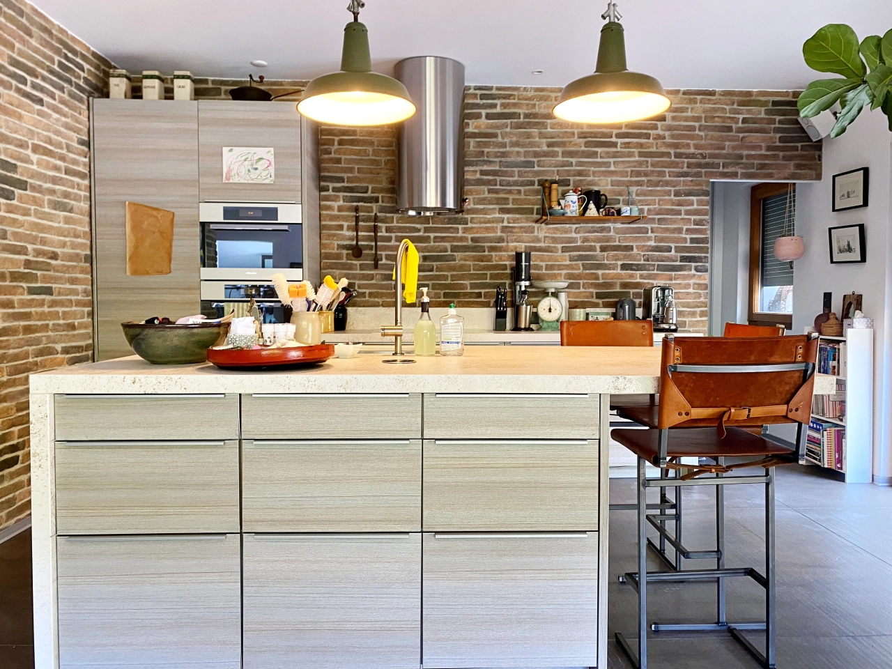 Moderne Küche mit Backsteinwand und Kochinsel