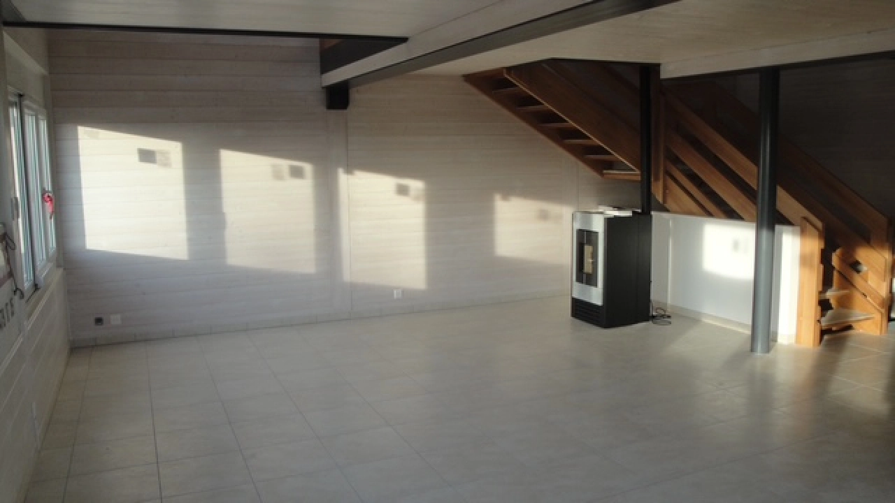 Leerer Wohnraum mit Kamin und Treppe