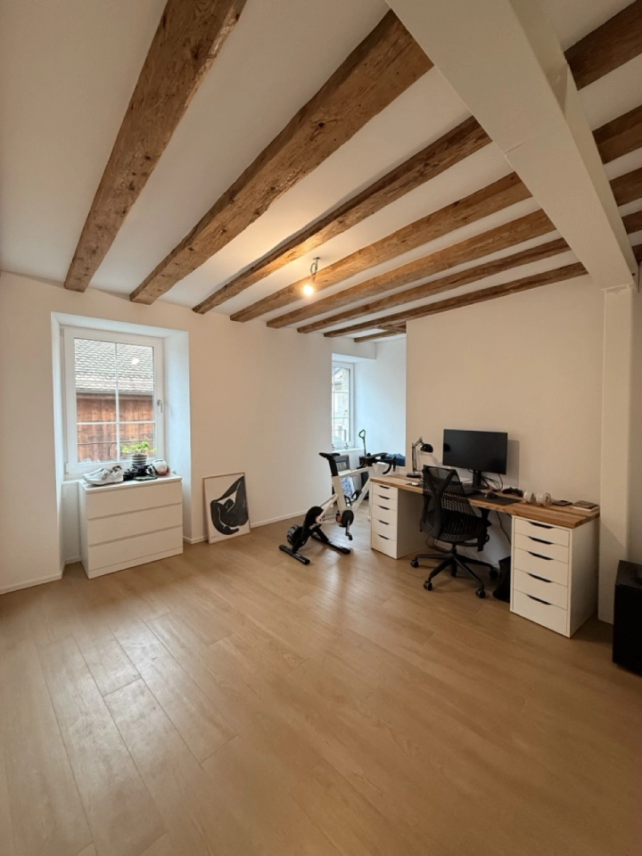 Dachgeschoss-Arbeitszimmer mit sichtbaren Holzbalken