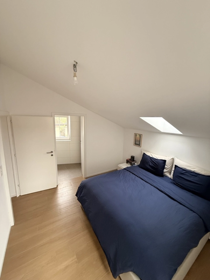 Dachgeschoss-Schlafzimmer mit Bett und Dachfenster
