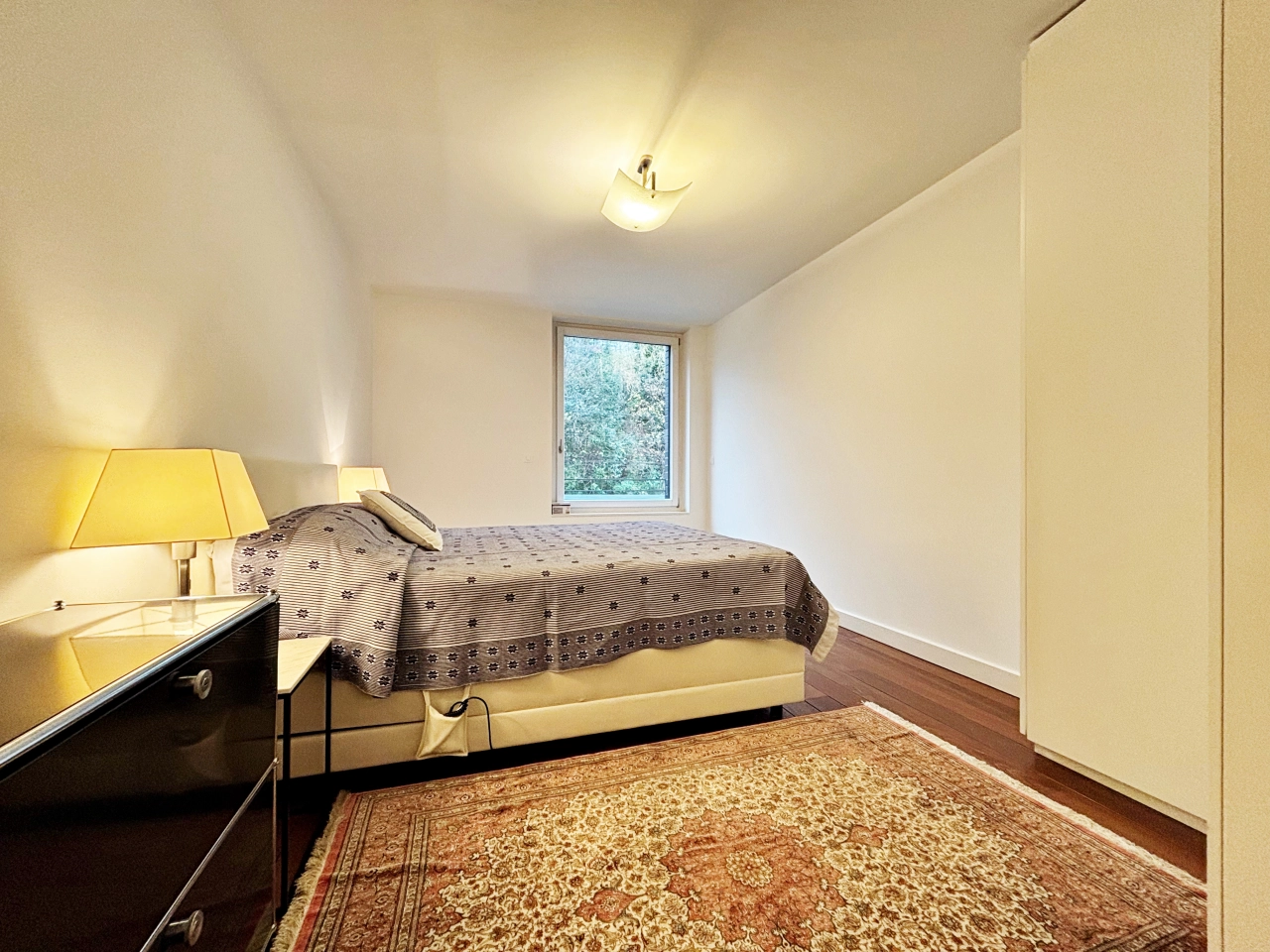 Helles Schlafzimmer mit Einzelbett und Fensterblick