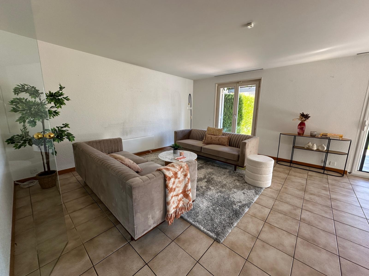 Wohnzimmer mit Terrassentür und Sitzgruppe