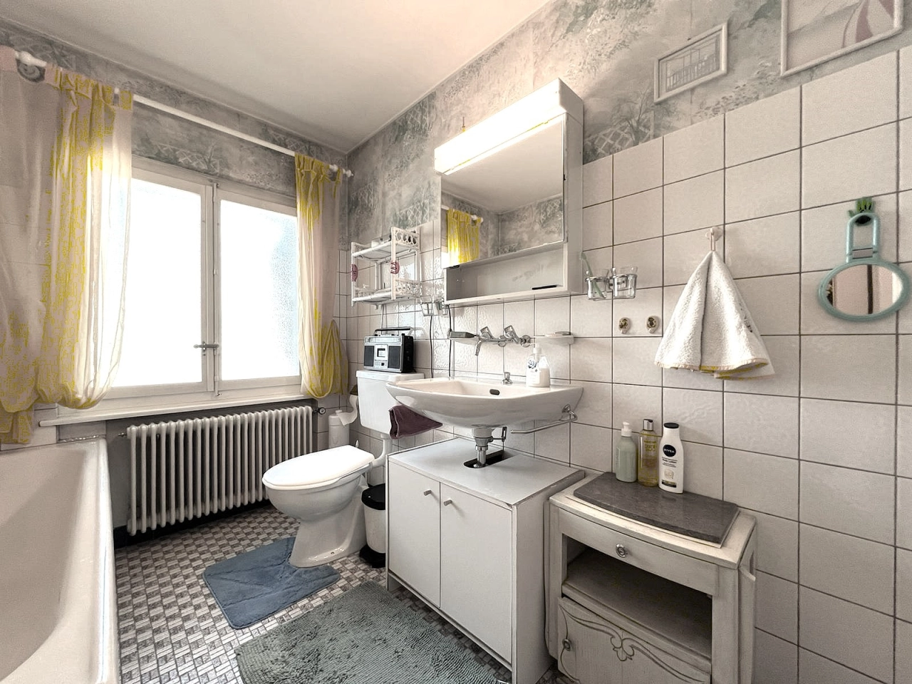 Badezimmer mit Fenster, Waschbecken und WC