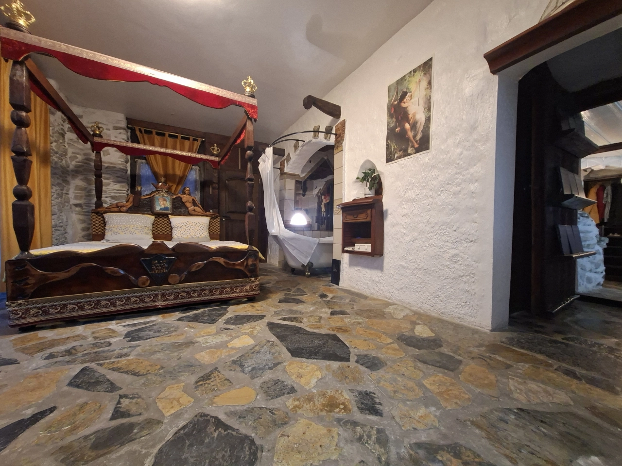 Schlafzimmer mit rustikalem Holzbett und Natursteinboden