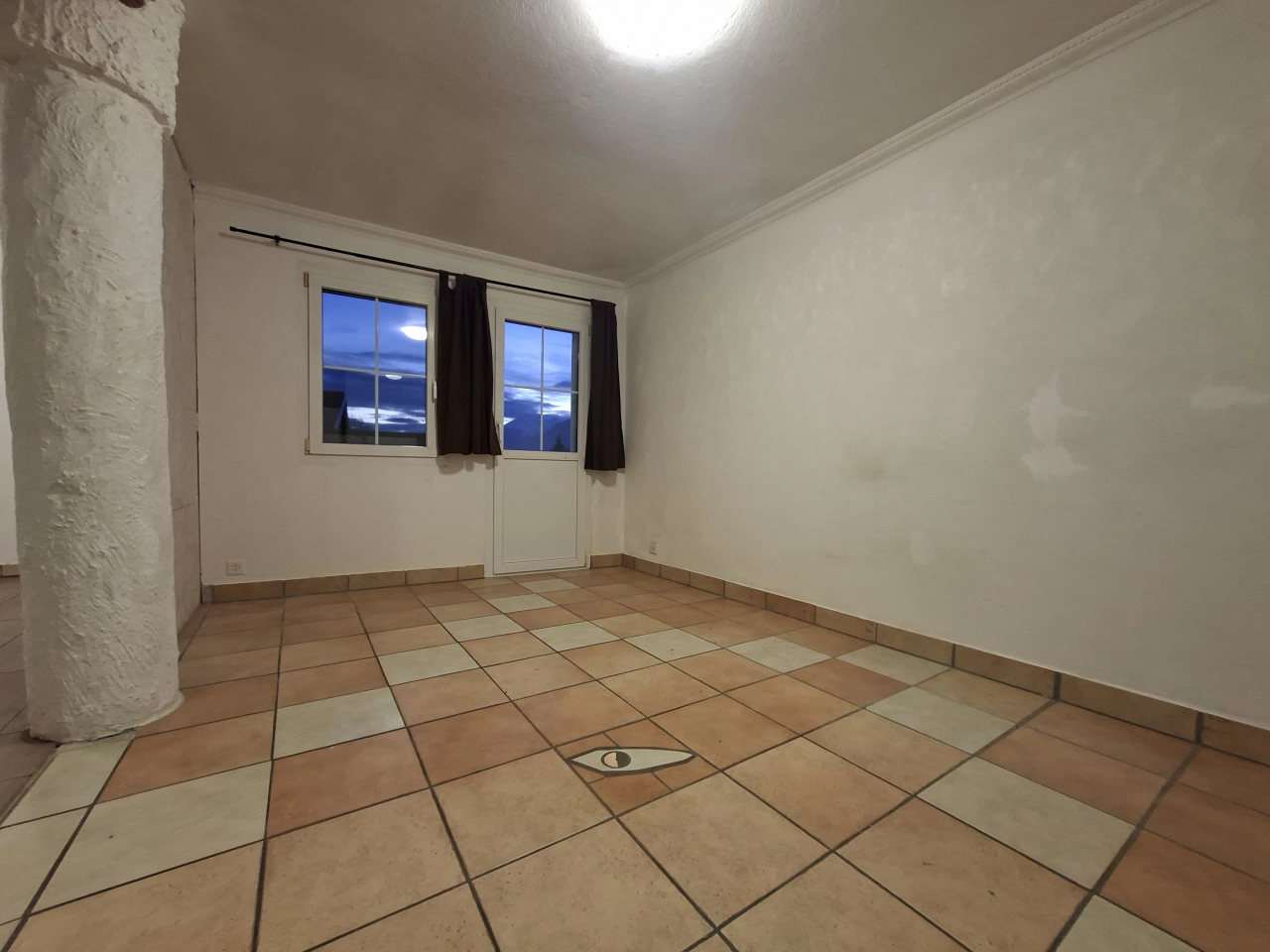 Leerer Raum mit Terrassentür und Fliesenboden