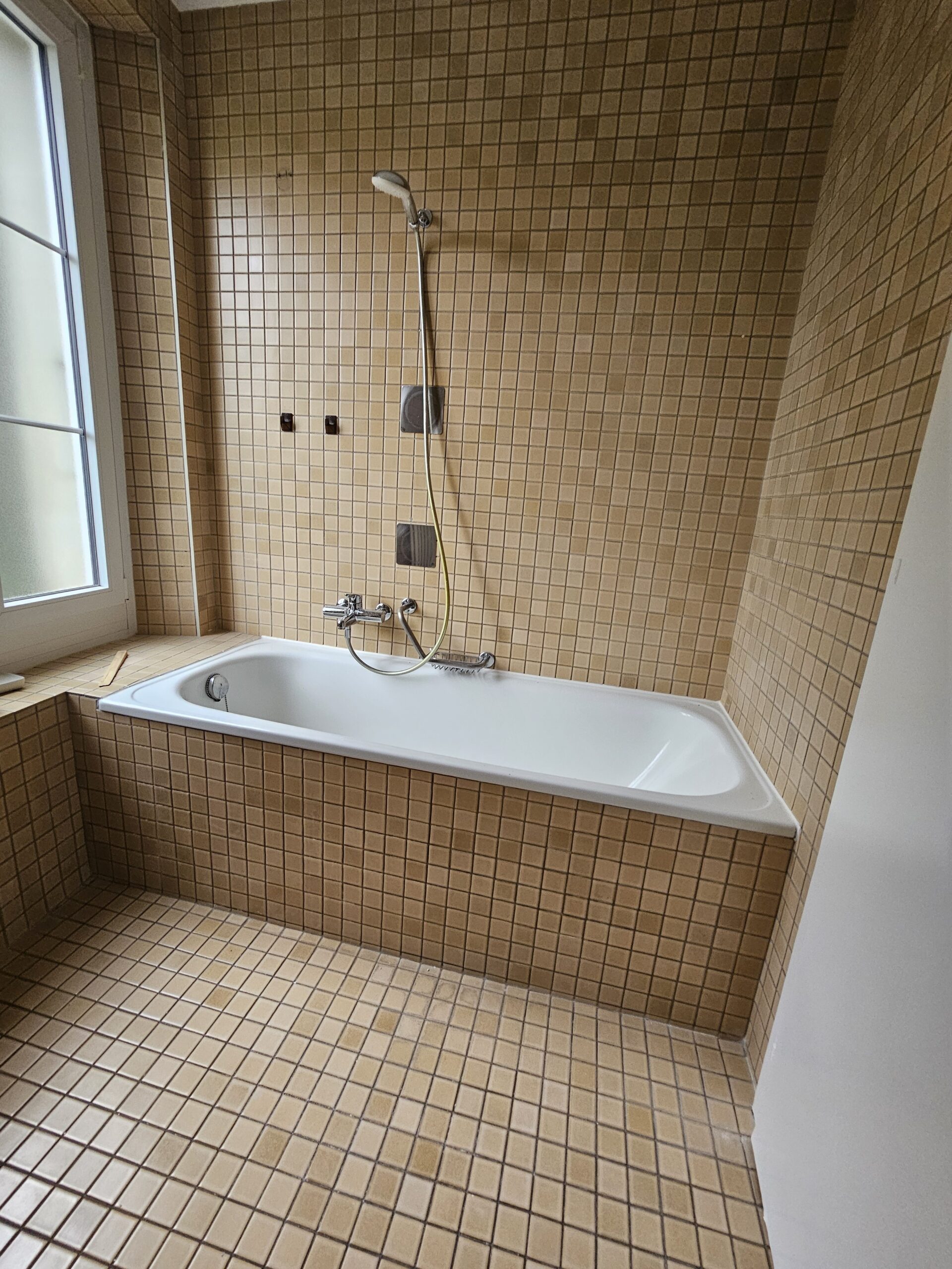 Badezimmer mit Fliesen und Badewanne