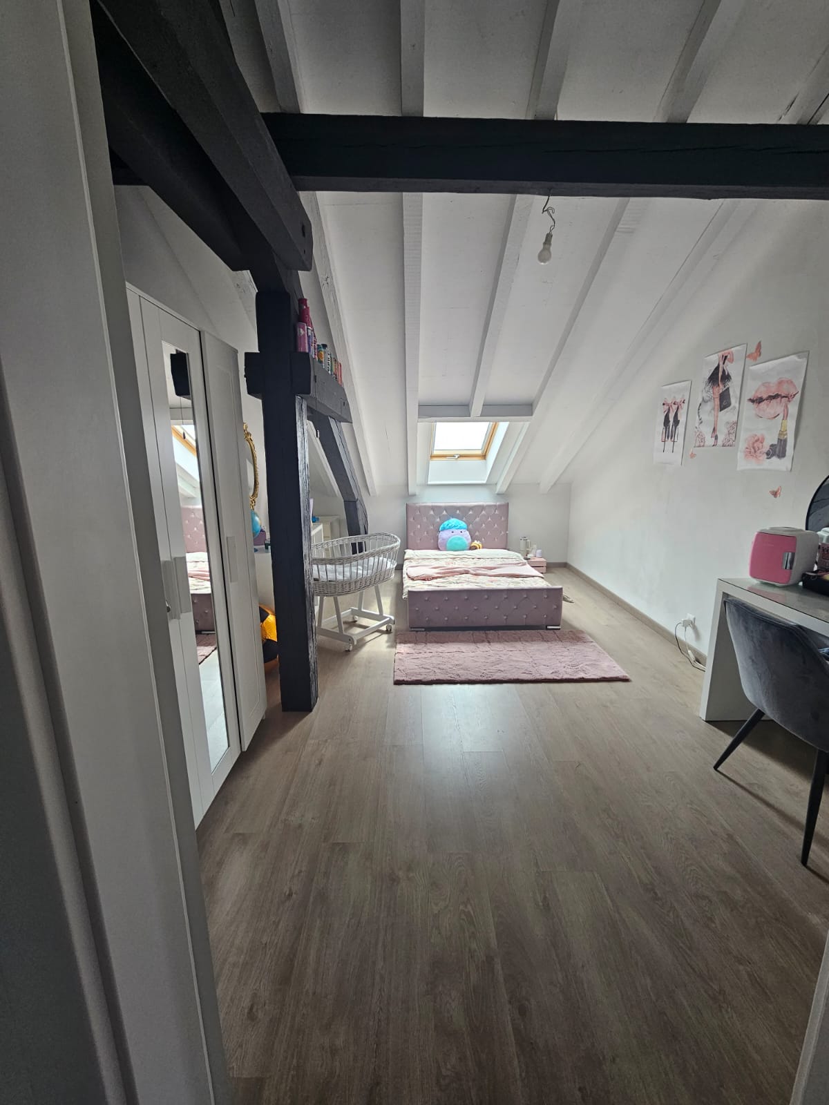 Dachgeschoss-Schlafzimmer mit sichtbaren Holzbalken