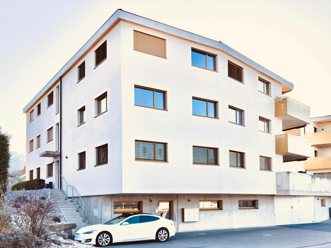 Mehrfamilienhaus mit weißer Fassade und Balkon