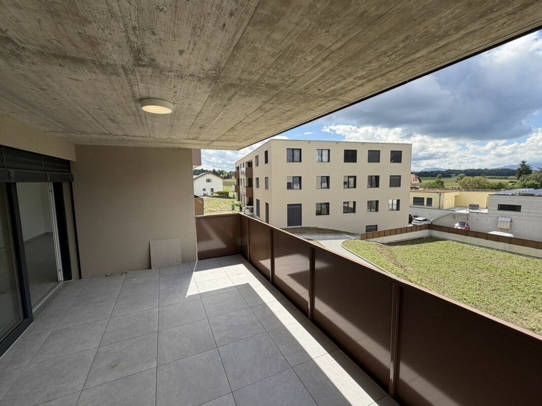Überdachter Balkon mit Ausblick auf Wohnanlage